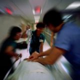 doctors rushing a man on a gurney down the hall