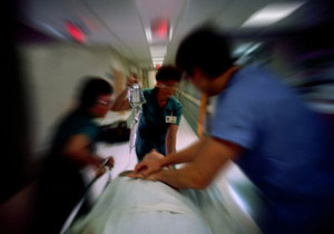 doctors rushing a man on a gurney down the hall